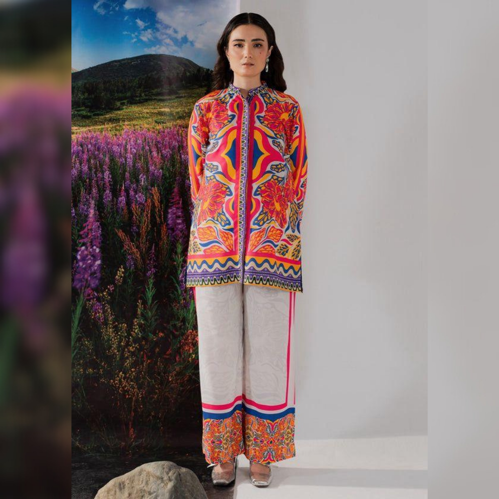 Woman wearing a colorful traditional outfit with a scenic background of purple flowers and mountains.