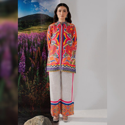Woman wearing a colorful traditional outfit with a scenic background of purple flowers and mountains.