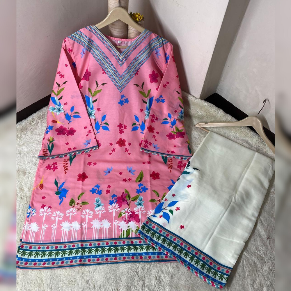 Pink floral dress with a matching white apron on hangers against a neutral wall.