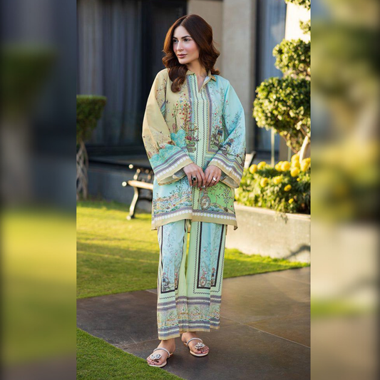 Woman in a light blue and green embroidered outfit standing outdoors.