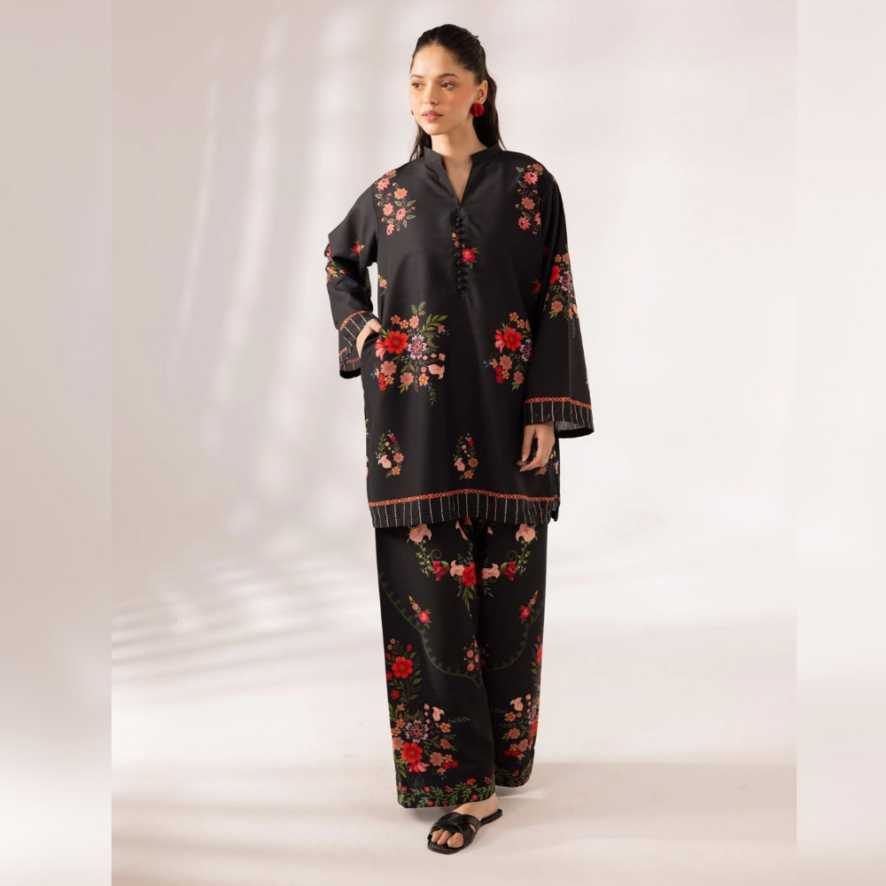 Woman wearing a black outfit with floral embroidery on a white background