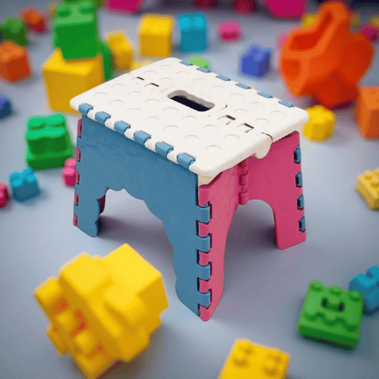 Colorful toy building block stool surrounded by scattered blocks on a light gray background