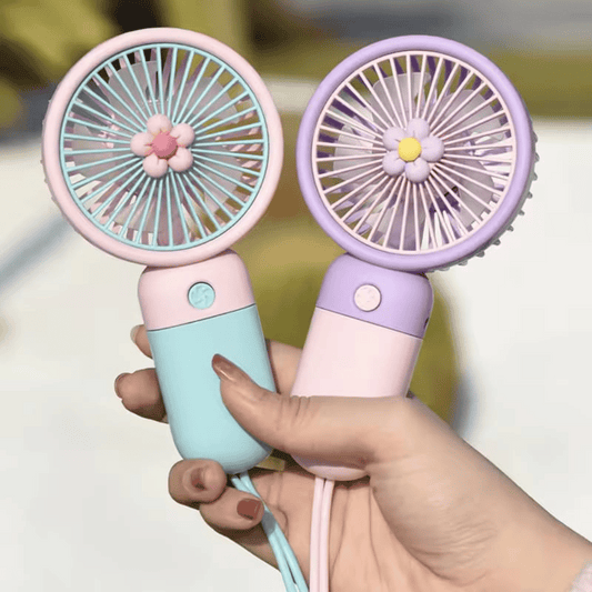 Two small handheld fans, one pink and one purple, held by a hand against a blurred background.