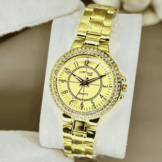 Gold wristwatch with diamond-studded bezel on a white cushion