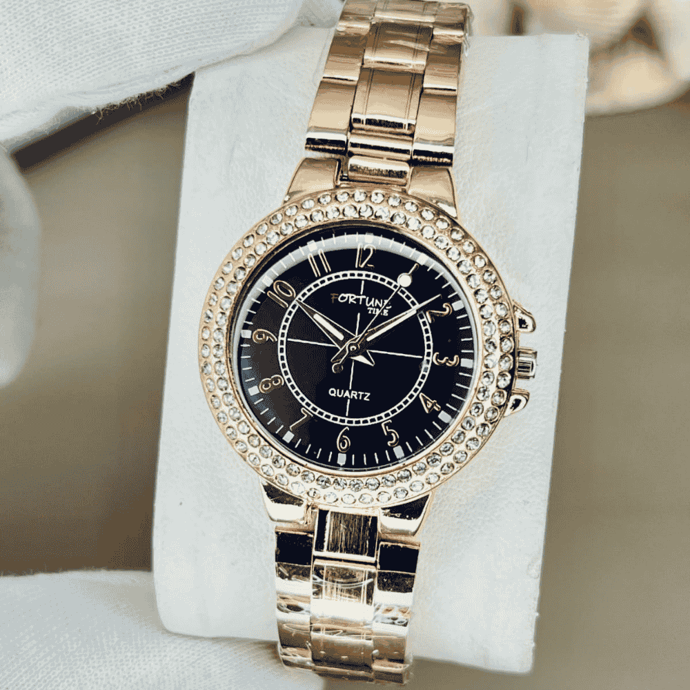 Gold wristwatch with black dial on a white stand
