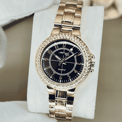 Gold wristwatch with black dial on a white stand