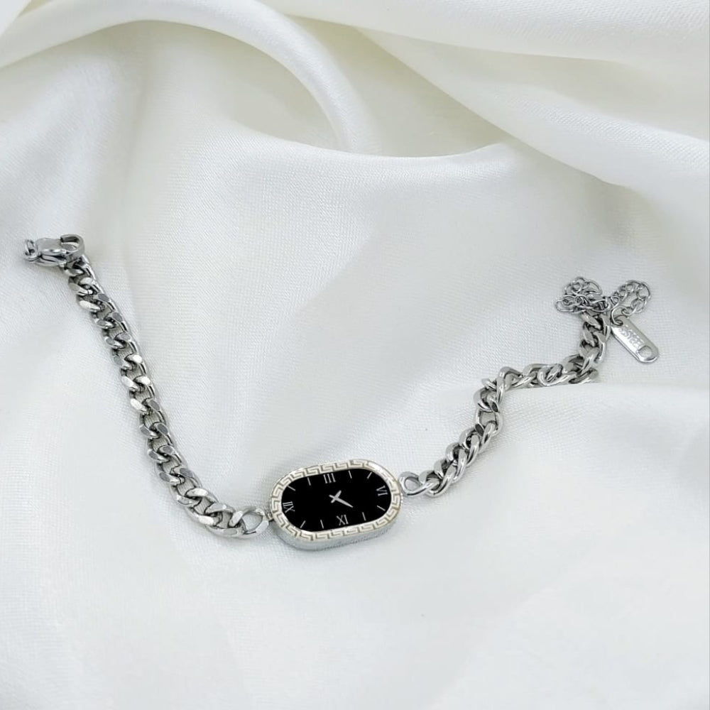 Silver bracelet with a black face on a white fabric background