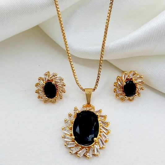 Gold necklace and earrings with black stones on a white fabric background