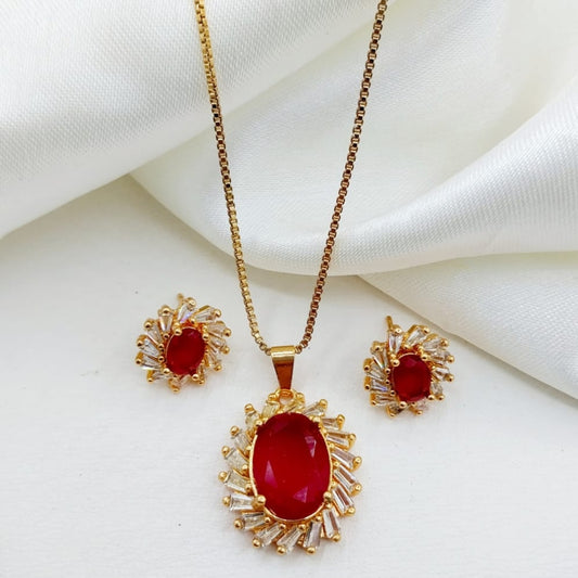 Gold jewelry set with red stones on a white fabric background