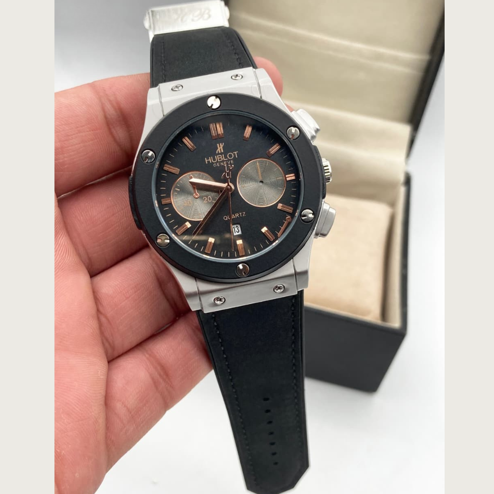 Hublot watch held in a hand with a neutral background