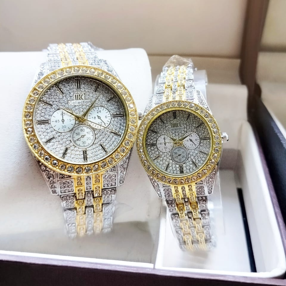 Pair of ornate gold and silver watches with diamond-studded faces on a white surface.