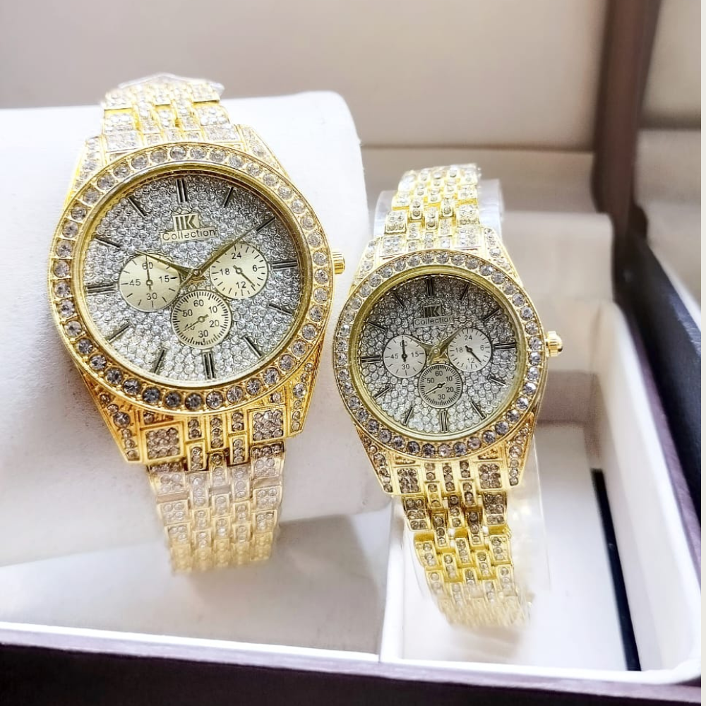Two gold watches with diamond-studded faces on a white surface.
