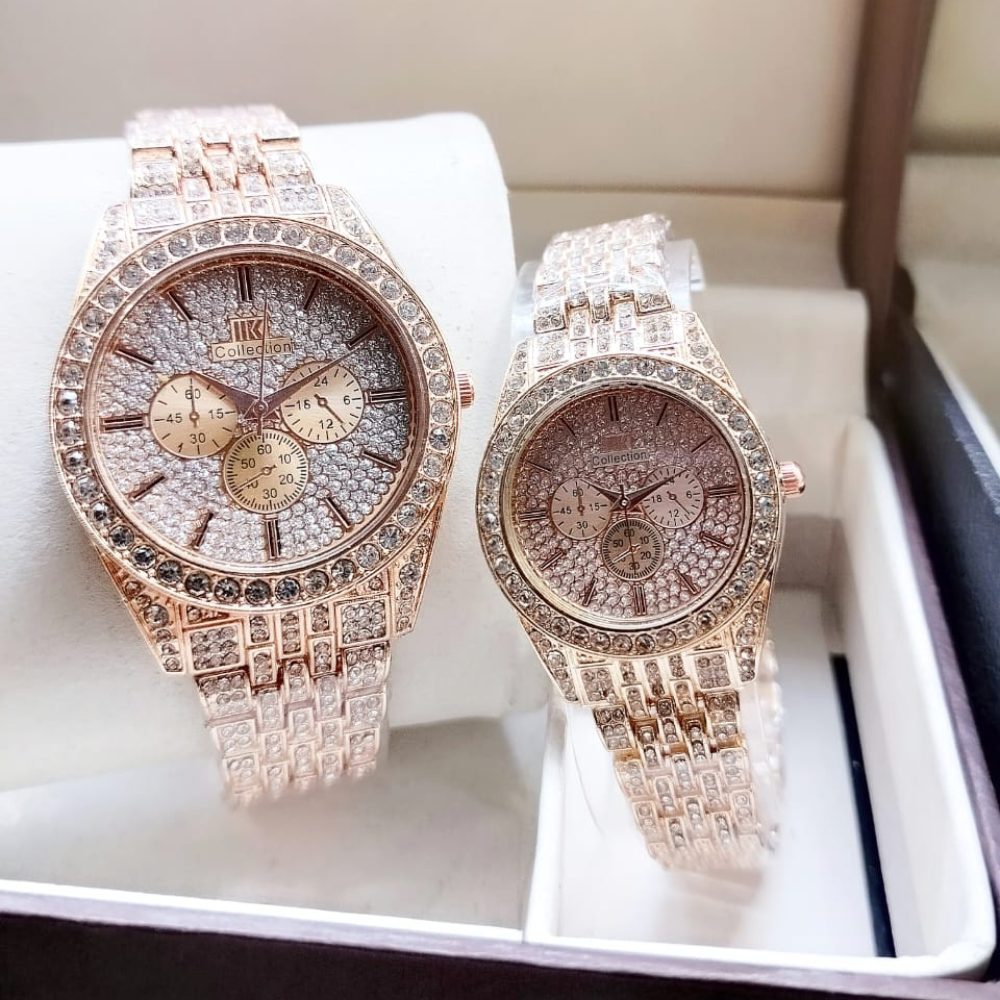 Two rose gold watches with diamond-studded faces on a white cushion.
