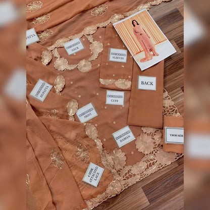 Brown embroidered fabric with labels on a wooden surface