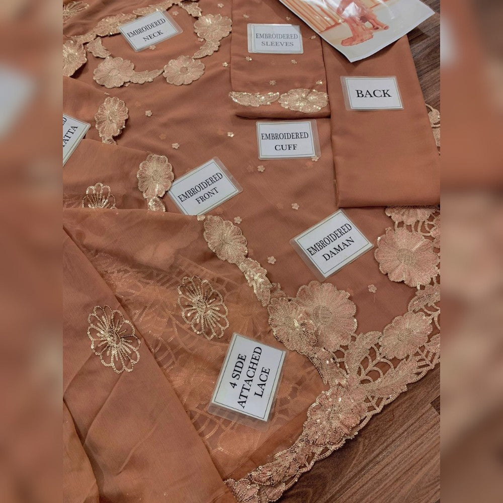 Brown fabric with gold embroidery and labels on a wooden surface