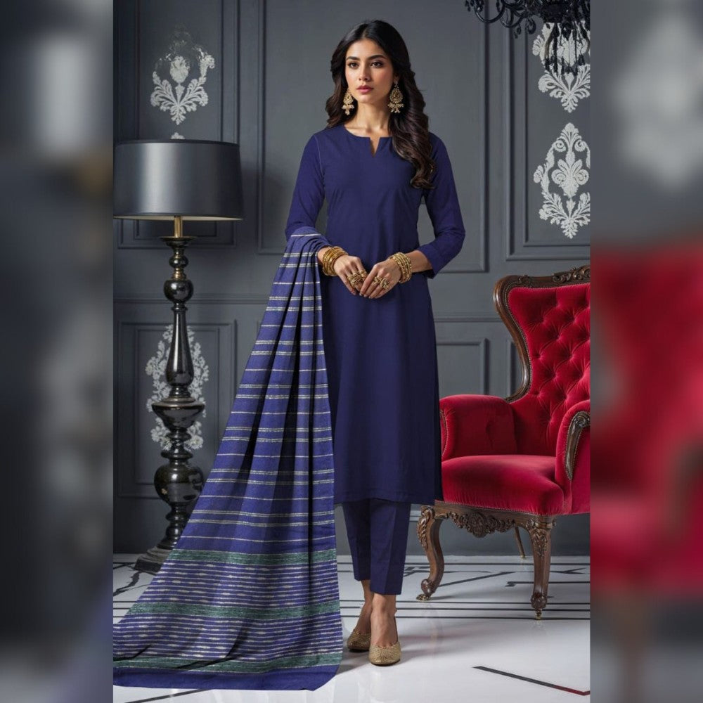 Woman in a blue traditional outfit with a red chair and decorative wall in the background