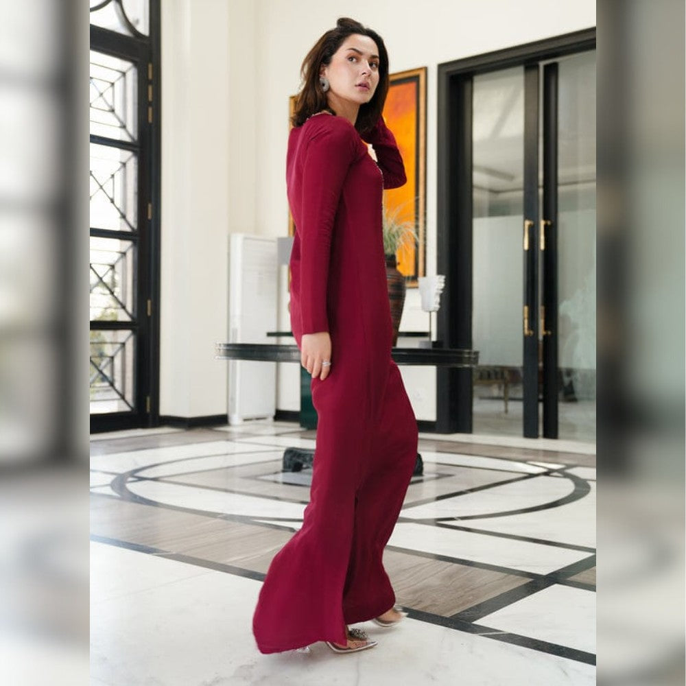 Woman in a red outfit standing in an elegant interior setting