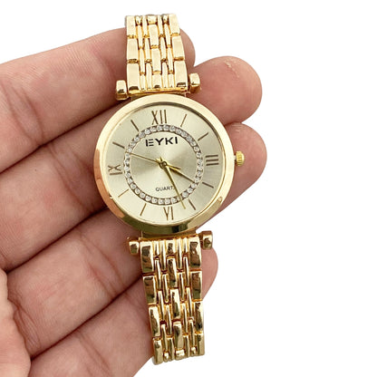 Gold watch with chain strap held in a hand on a white background