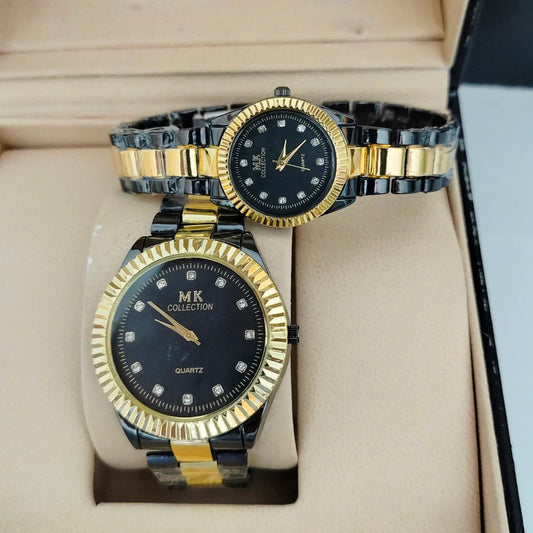 Two gold and black watches with diamond-studded faces on a beige cushion.