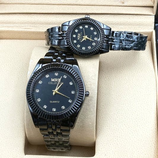 Two black wristwatches with diamond-studded faces on a beige cushioned surface.