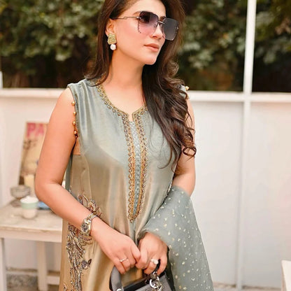 Woman wearing a light green embroidered dress with sunglasses outdoors