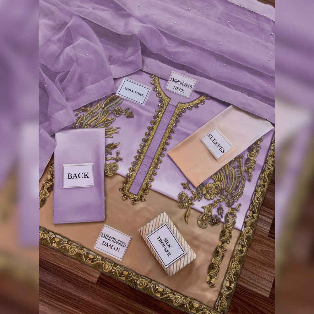 Purple fabric with embroidered details and labels on a wooden surface
