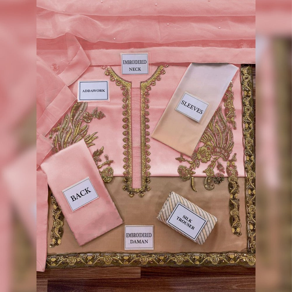 Pink and gold embroidered fabric pieces with labels on a decorative pink background
