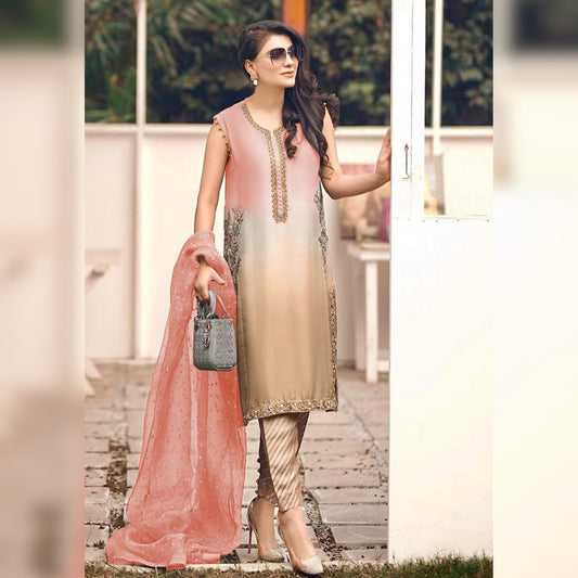 Woman in a traditional outfit with a pink dupatta standing outdoors.