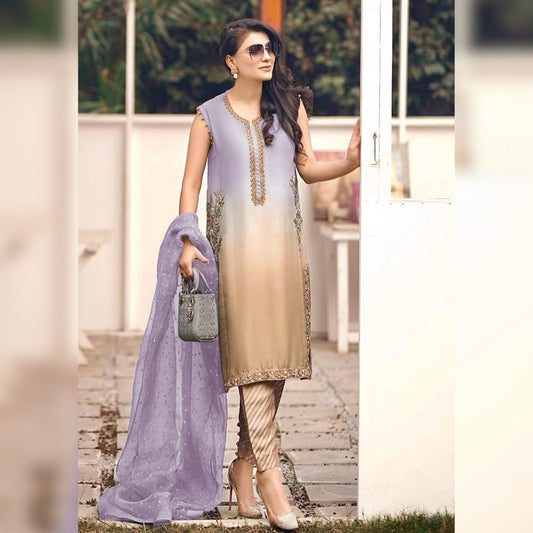Woman in a light purple and beige traditional outfit standing outdoors.