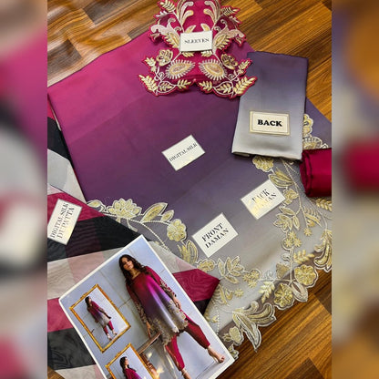 Fabric display with purple and gray material, gold embroidery, and a model photo on a wooden surface.