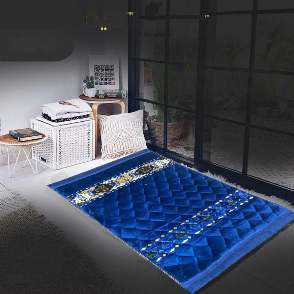 Blue prayer mat with intricate patterns on a dark floor, room setting.