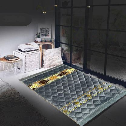 Gray textured rug with yellow pattern on a dark floor, room interior in the background