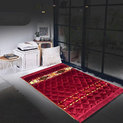 Red patterned rug on a dark floor with a white wall and furniture in the background