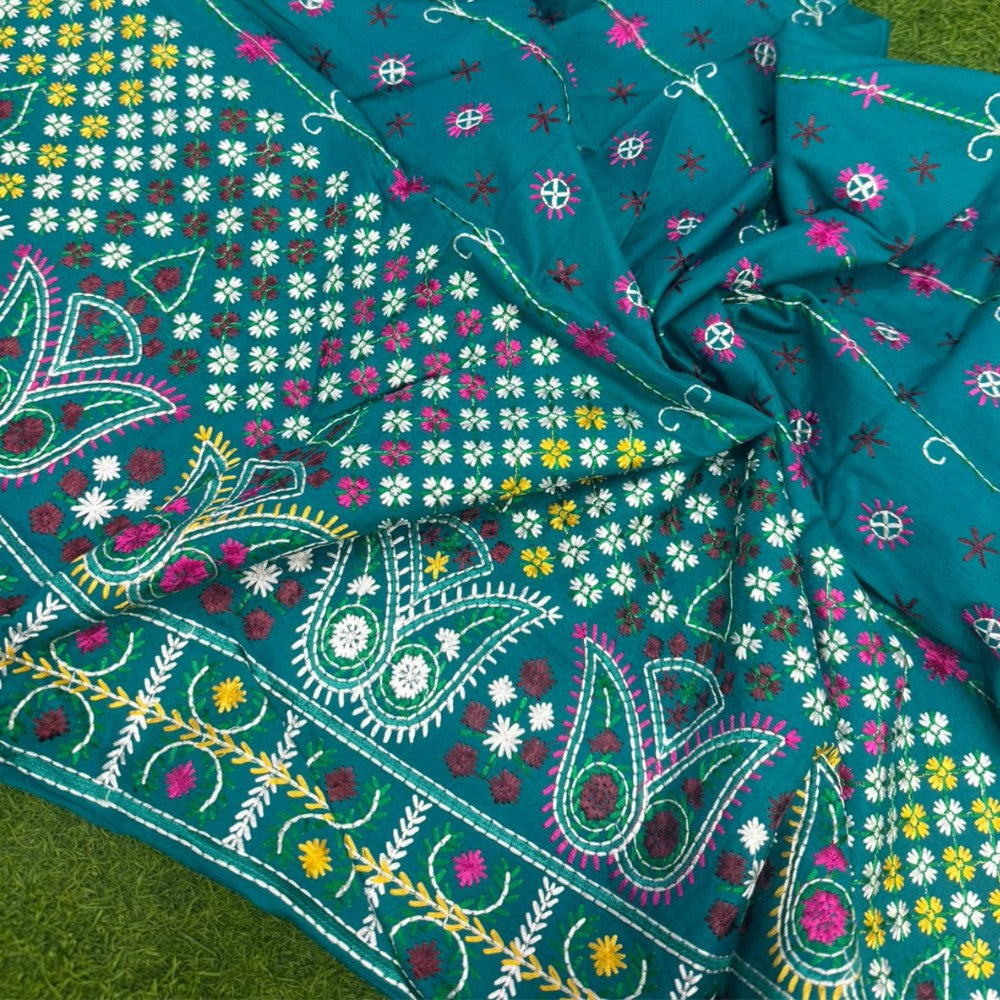 Close-up of a colorful fabric with floral and paisley patterns on a green background