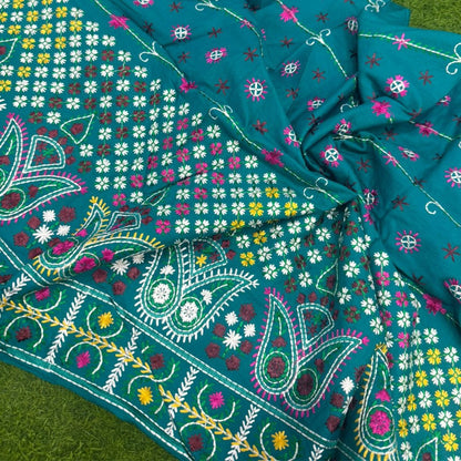 Close-up of a colorful fabric with floral and paisley patterns on a green background