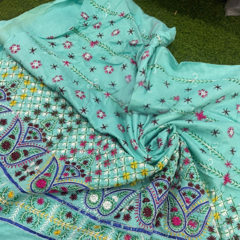 Turquoise fabric with intricate patterns on a green background
