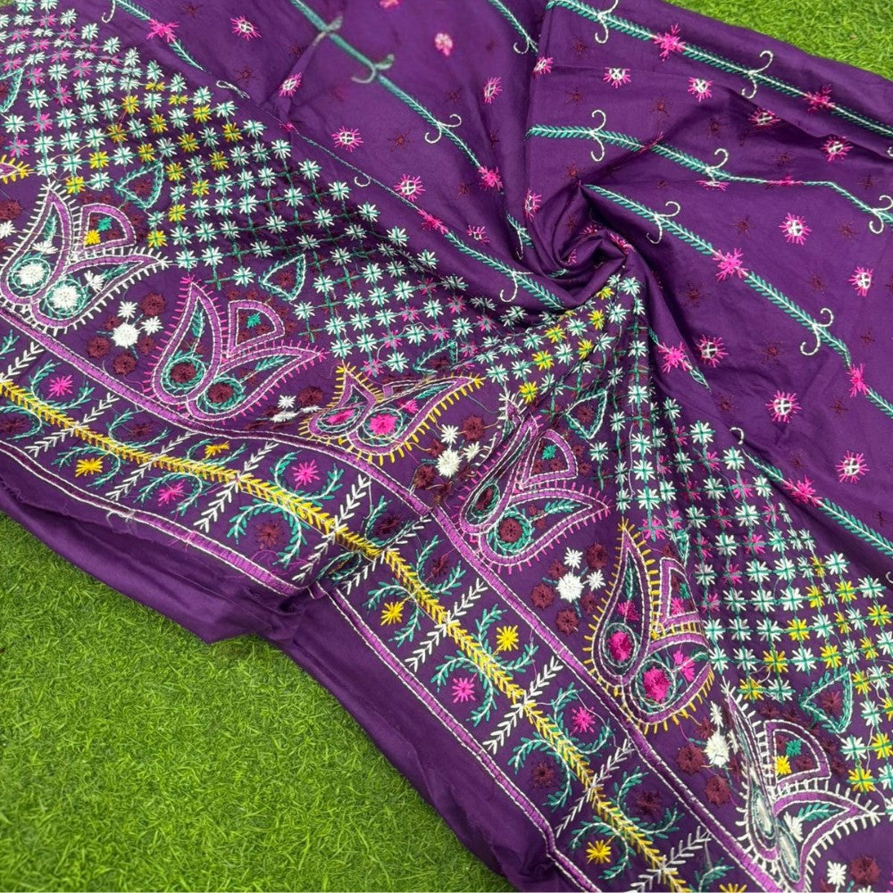 Purple fabric with colorful embroidery on a green background