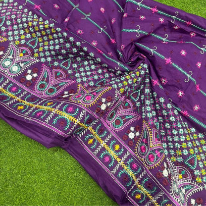 Purple fabric with colorful embroidery on a green background