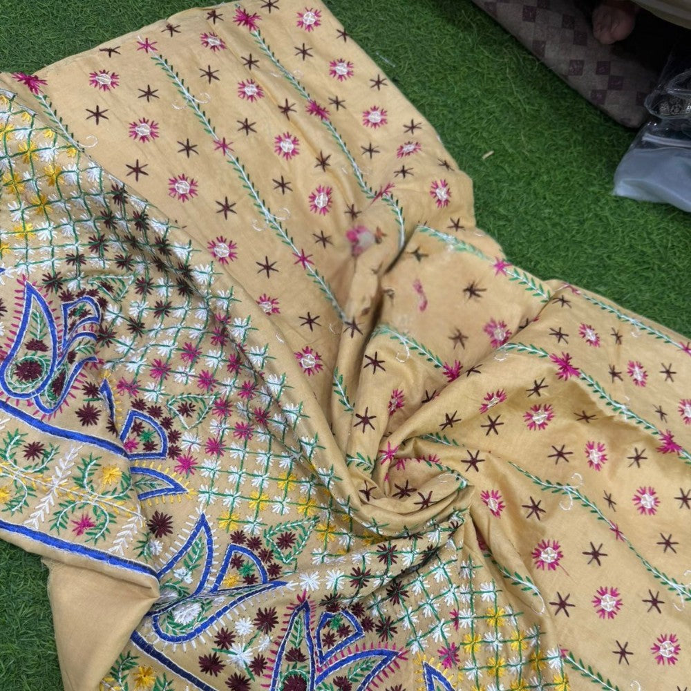 Embroidered fabric with floral and paisley patterns on a green surface