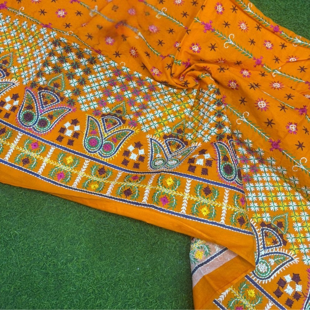 Orange fabric with intricate patterns on a green background