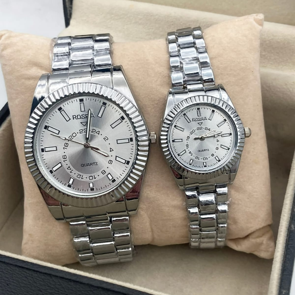 Two silver wristwatches on a beige cushion with a blurred background