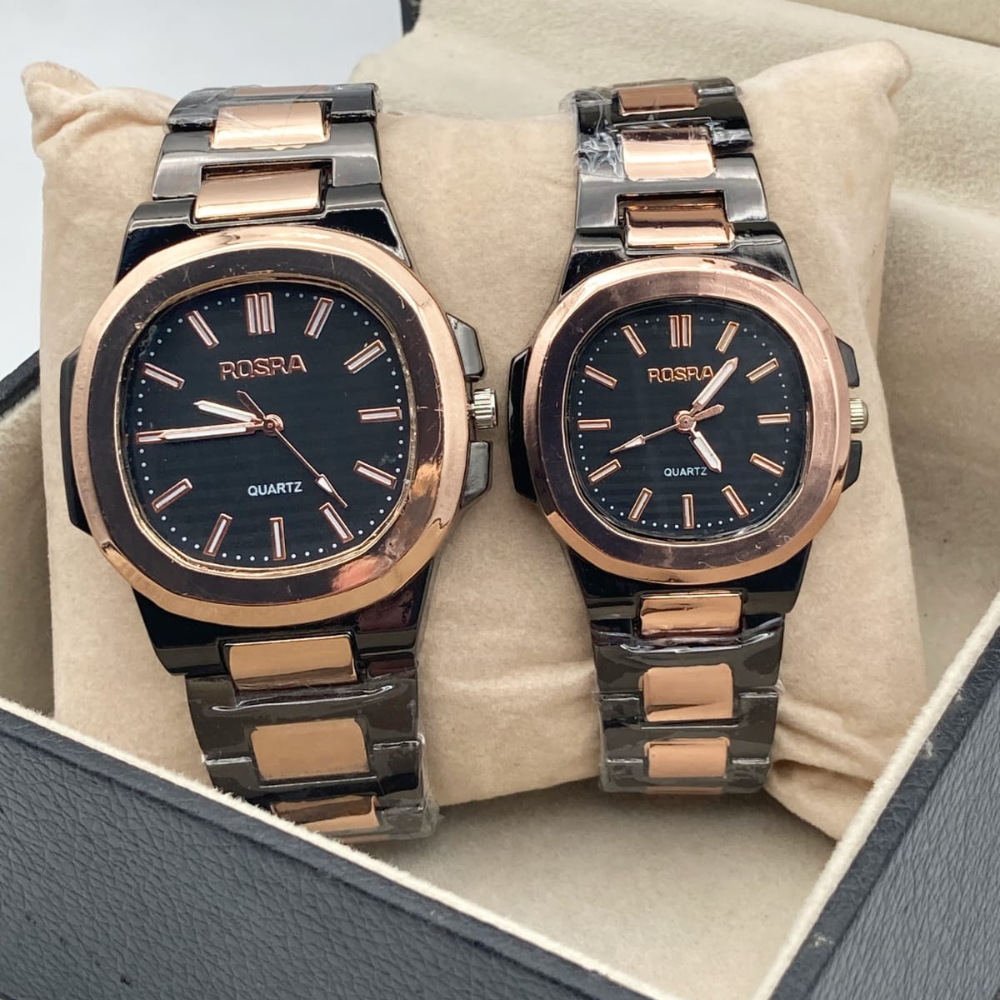 Two Rosra watches with rose gold and black faces on a beige cushion.