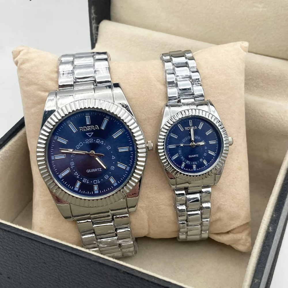 Two silver watches with blue faces on a beige cushion inside a box.