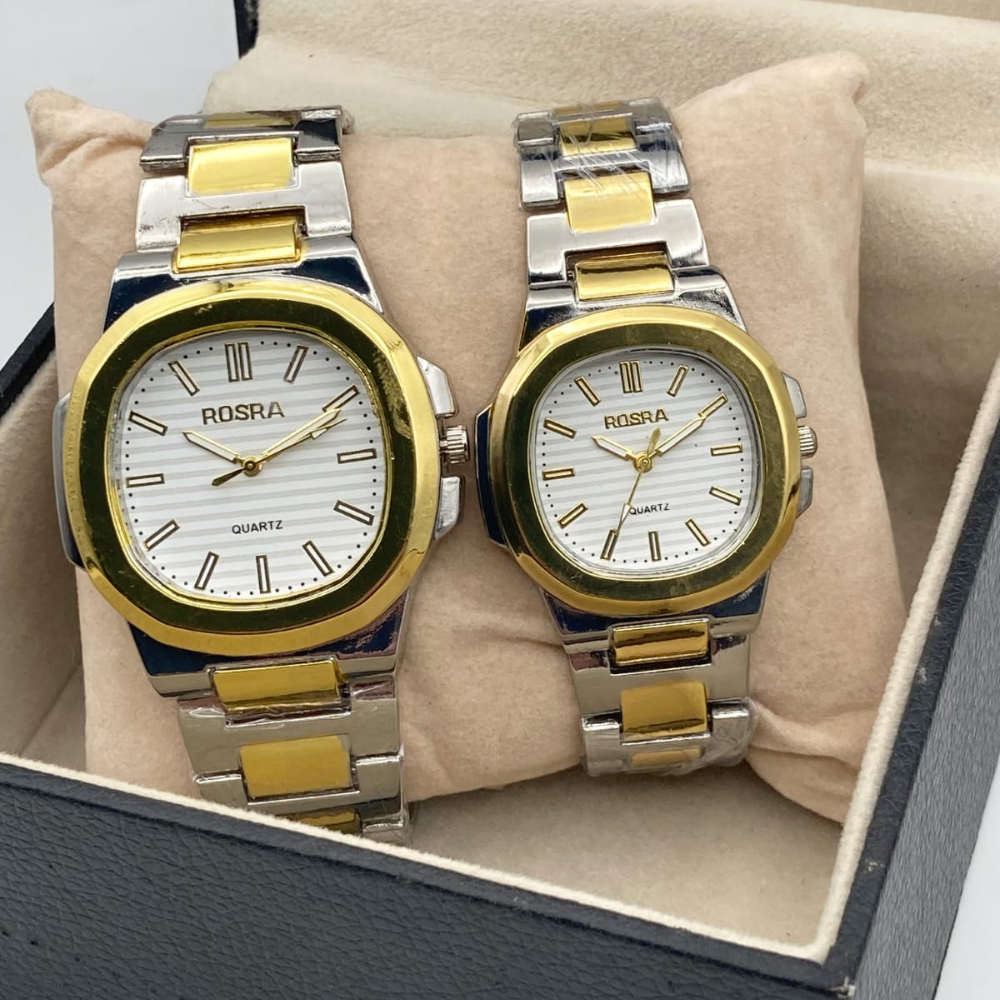 Two Rosra watches with gold and silver straps on a beige cushion inside a box.