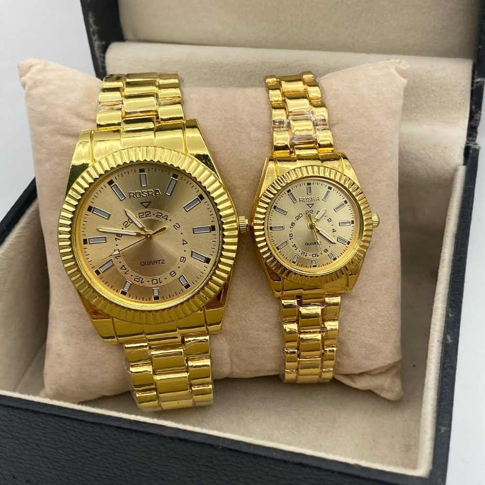 Two gold watches in a box on a beige cushion