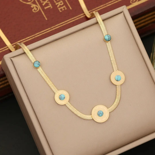 Sea green and golden locket displayed on a box – side view
