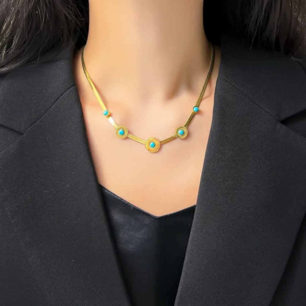 Golden and sea green locket worn on neck – front view