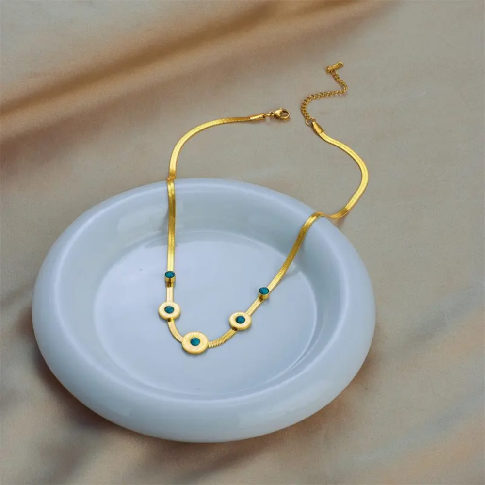 Side angle of sea green stone locket on jewelery plate