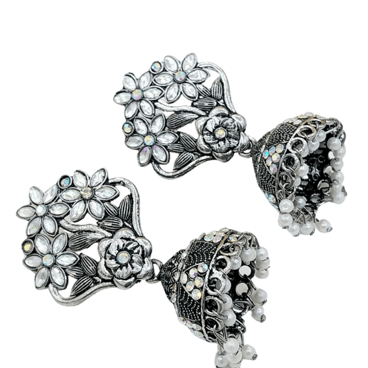 Upper front angle of shiny silver earrings with floral pattern