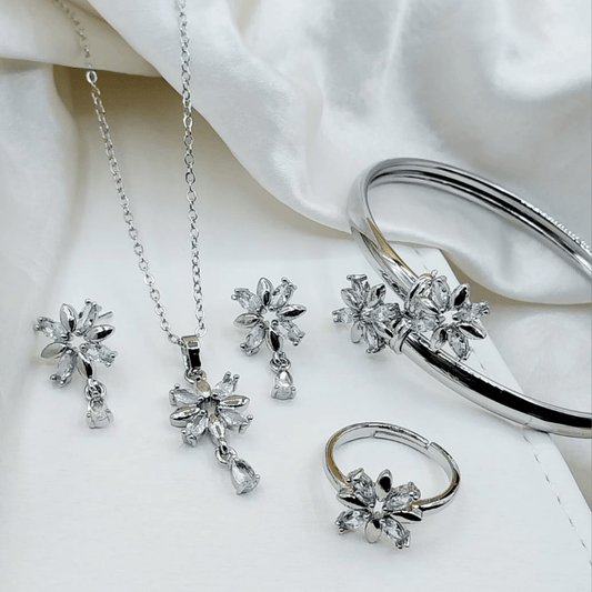 Elegant silver locket set with matching bangle and ring displayed on a velvet background.